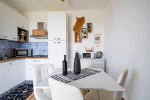 a white kitchen with a white table and white chairs at Casa Jerzu S'essia de su santu in Jerzu +15 photos