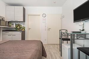 a bedroom with a bed and a table and a kitchen at Apartment mit Kaffeeküche für Zwei in Meersburg