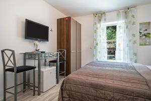 a bedroom with a bed and a tv and a window at Apartment mit Kaffeeküche für Zwei in Meersburg