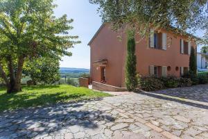 a house with a tree and a stone driveway at Appartamento Il Nespolo in Pontedera