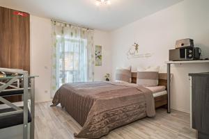 a bedroom with a bed and a window with a microwave at Apartment mit Kaffeeküche für Zwei in Meersburg