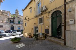 a building with a green door on a street at Vico21 nel centro di Modica in Modica
