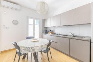 a kitchen with a table and chairs in a room at Vico21 nel centro di Modica in Modica