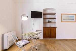 a room with a table and chairs and a television at Vico21 nel centro di Modica in Modica