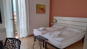 a bedroom with a large white bed and a chair at Liver 202 in Tremosine Sul Garda