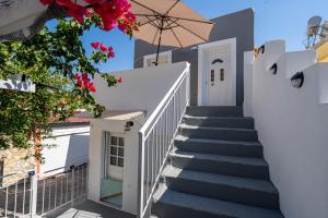 a staircase leading up to a white house with an umbrella at Kate House in Ágios Matthaíos