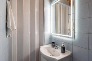 a white bathroom with a sink and a mirror at Kate House in Ágios Matthaíos