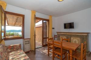 a dining room with a wooden table and a television at Trilocale N8 - Porto Mannu in Palau