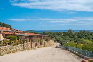 an empty road in front of a stone wall at Trilocale N8 - Porto Mannu in Palau