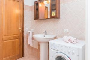 a bathroom with a sink and a washing machine at Home Residence Barbara in San Teodoro