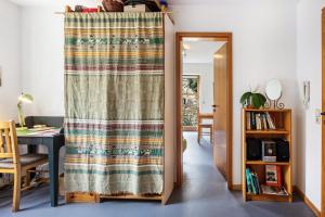 a curtain in a room with a table and a desk at Sonnige Wohnung im Markgräflerland in Efringen-Kirchen