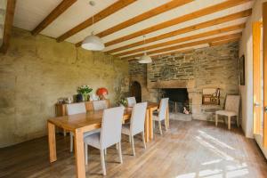 a dining room with a wooden table and a fireplace at Moulin du Tourous - Chambre 1 in Plouédern