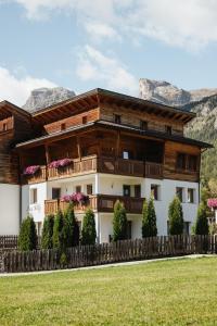a house with a balcony and mountains in the background at Ciasa Willy App Sas La Crusc in La Villa