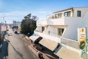 a white building on the side of a street at Blue Bay Lux House in Torre Lapillo