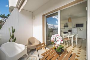 a room with a balcony with a table and chairs at Blue Bay Lux House in Torre Lapillo +28 photos