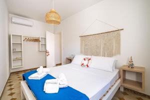 a bedroom with a large white bed with towels on it at Blue Bay Lux House in Torre Lapillo