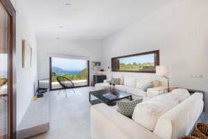 a living room with white furniture and large windows at Dream Property in Alconasser in Sóller