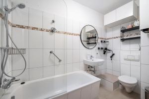 a bathroom with a tub and a toilet and a sink at Ferienwohnung Krause Dachgeschoss in Wilhelmshaven +15 photos