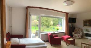 a bedroom with a bed and a window and a chair at Ferienwohnung Mi Ka mit Garten in Limburg an der Lahn