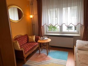 a living room with a chair and a table and a window at Ferienwohnung Mi Ka mit Garten in Limburg an der Lahn
