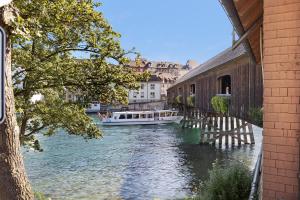 a boat on a river next to a building at am Hochrhein Desko in Gailingen