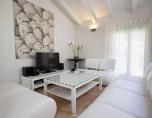 a white living room with a table and a tv at Gailupa in San Martín