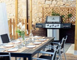 a wooden table with chairs and a grill in a yard at Gailupa in San Martín