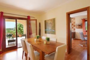 a dining room with a wooden table and chairs at Cas Cans in Artá
