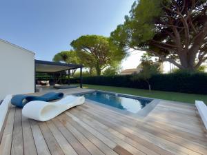 a backyard with a swimming pool and a wooden deck at Villa bord de mer avec piscine in Hyères