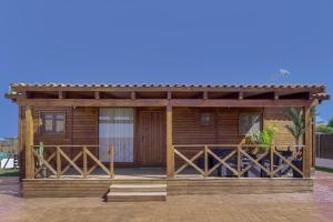 a wooden cabin with a porch and a deck at Villa Fatema in Conil de la Frontera