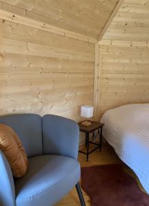a bedroom with a bed and a couch and a lamp at Le Kota Du Paradou in Givet