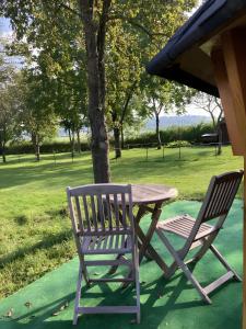 a picnic table and two chairs next to a tree at Le Kota Du Paradou in Givet