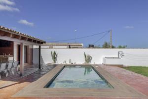 a swimming pool in the backyard of a house at Villa Fatema in Conil de la Frontera