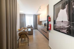 a living room with a table and a kitchen at Luxury Apartment Valley Views B11 in Xagħra