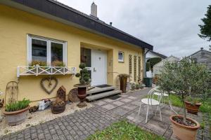 a yellow house with a window and some plants at Casa Limone in Ammerbuch