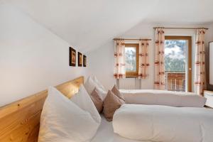 a white living room with white pillows and a couch at Mair am Tinkhof in Selva dei Molini