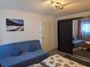 a living room with a blue couch and a mirror at Schiller´s Urban Escape in Freudenstadt