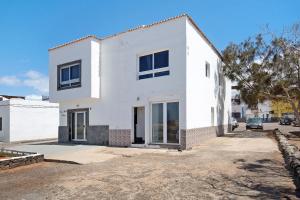 a white house on a street at El Cotillo Mar Sea View in El Cotillo