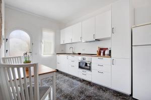 a kitchen with white cabinets and a wooden table at El Cotillo Mar Sea View in El Cotillo