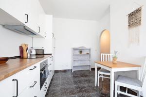 a kitchen with white cabinets and a wooden table at El Cotillo Mar Sea View in El Cotillo +23 photos