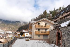 a building with a balcony on the side of a mountain at Alpen Blumen in San Lorenzo in Banale