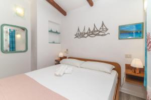 a bedroom with a white bed and a mirror at Villa Maffy in Baja Sardinia +27 photos