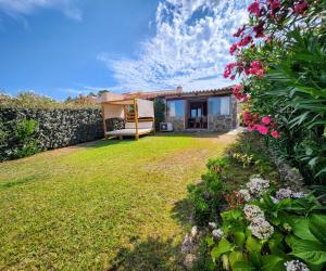 a house with a garden and a yard with flowers at Villa Maffy in Baja Sardinia