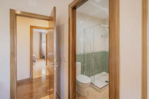 a bathroom with a toilet and a glass shower at El Cauce in Navaluenga +21 photos