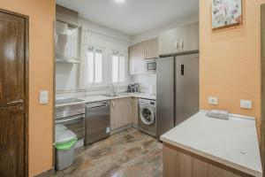 a kitchen with a refrigerator and a dishwasher at El Cauce in Navaluenga