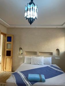 a bedroom with a large bed with a chandelier at Mirage House in Mirleft