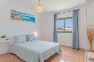 a bedroom with a bed and a large window at Apartamento La Dehesa - Uga in Uga