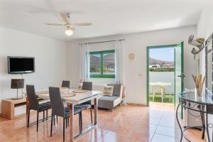 a dining room and living room with a table and chairs at Apartamento La Dehesa - Uga in Uga