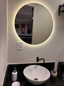 a bathroom with a sink and a mirror at Studio 01 JD Paulistano in Ribeirão Preto +10 photos