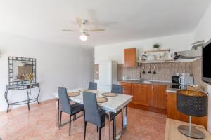 a kitchen with a table and chairs in a room at Apartamento La Dehesa - Uga in Uga +13 photos